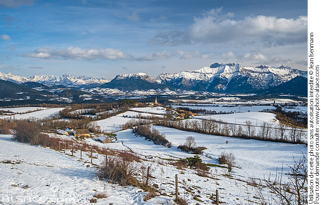 Photo : Village de Le Percy dans la région du Trièves en hiver et le massif du Dévoluy en arrière-plan, Isère (38) - (ref. 250102-004) © Jean Isenmann