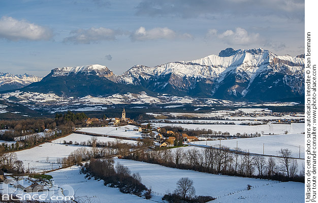 Photo : Village de Le Percy dans la région du Trièves en hiver et le massif du Dévoluy en arrière-plan, Isère (38) - (ref. 250102-013) © Jean Isenmann