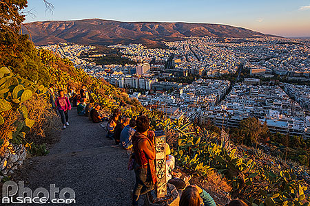 Photo : Touristes regardant le coucher de soleil sur Athènes au sommet du Mont Lycabette, Grèce