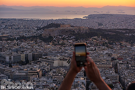 Photo : Touriste faisant une photo au smartphone depuis le mont Lycabette, Athènes, Grèce